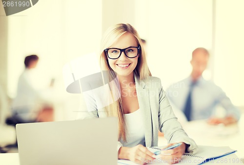 Image of businesswoman with documents in office