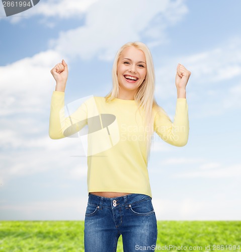 Image of laughing young woman with hands up