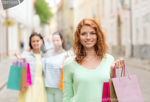 Image of smiling teenage girls with shopping bags on street