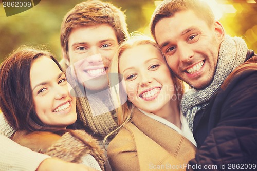 Image of group of friends having fun in autumn park