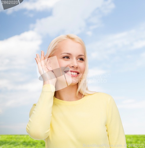 Image of smiling young woman listening to gossip