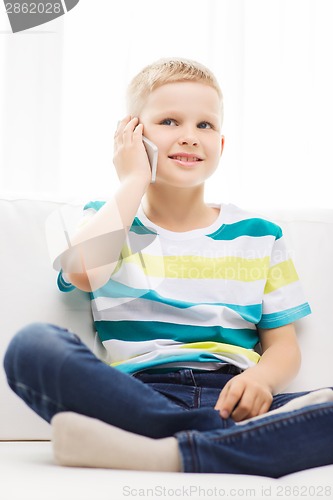 Image of smiling little boy with smartphone at home