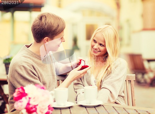 Image of romantic man proposing to beautiful woman