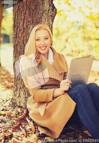 Image of woman with tablet pc in autumn park