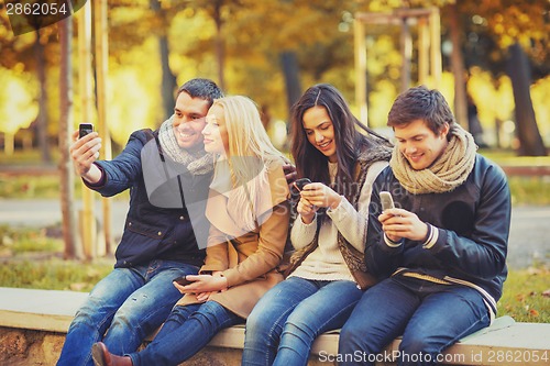 Image of group of friends having fun in autumn park