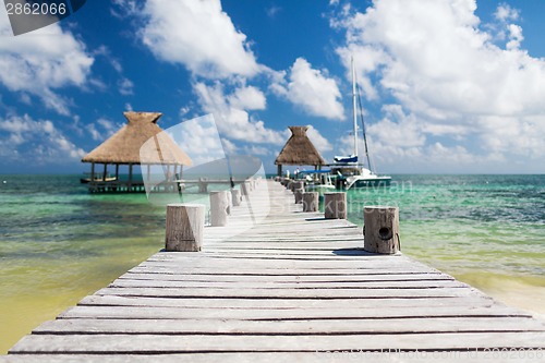 Image of wooden pier with blue water around