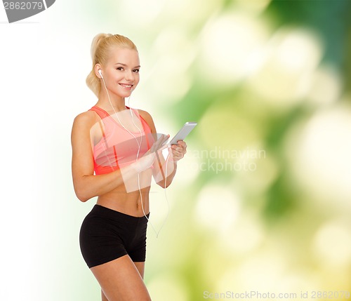 Image of smiling sporty woman with smartphone and earphones