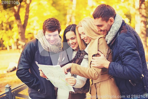 Image of couples with tourist map in autumn park