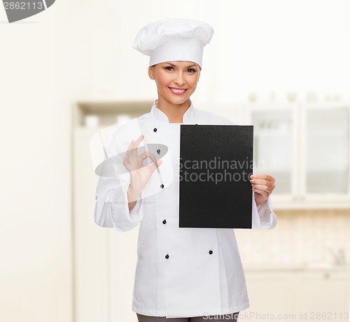 Image of smiling female chef with black blank paper