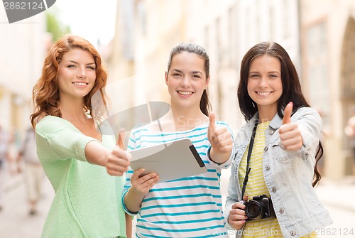 Image of smiling teenage girls with tablet pc and camera