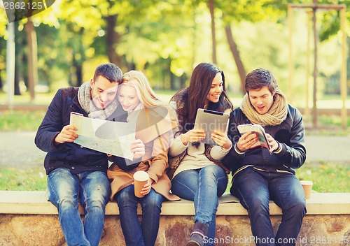 Image of couples with tourist map in autumn park