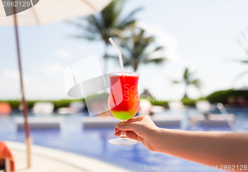 Image of close-up of hand holding glass with cocktail