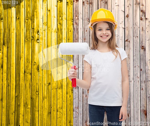 Image of smiling little girl in helmet with paint roller