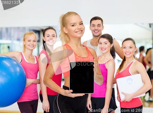 Image of smiling woman showing tablet pc blank screen