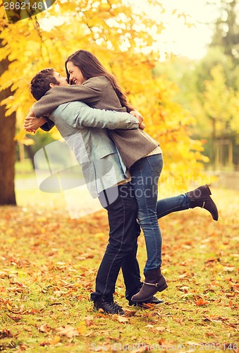 Image of romantic couple playing in the autumn park