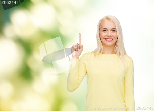 Image of smiling woman pointing her finger up