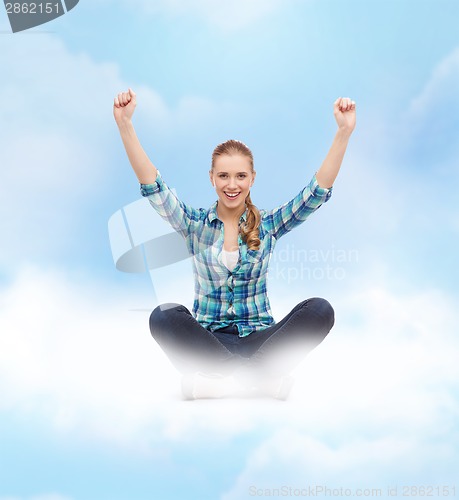 Image of young woman in casual clothes sitting on floor