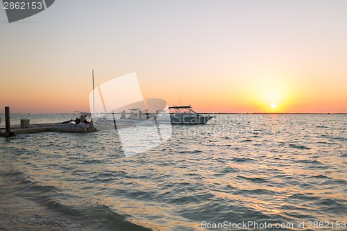 Image of boats moored to pier at sundown