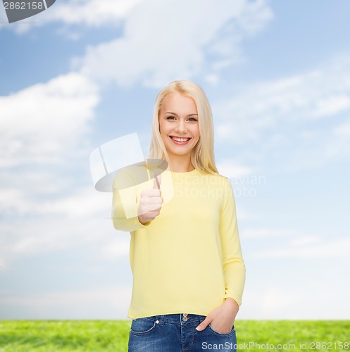 Image of smiling girl in casual clothes showing thumbs up