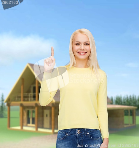 Image of smiling woman pointing her finger up