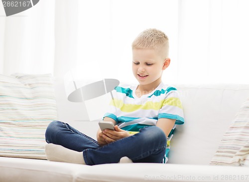 Image of smiling little boy with smartphone at home