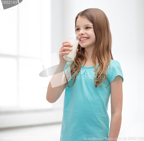 Image of smiling little girl drinking milk out of glass