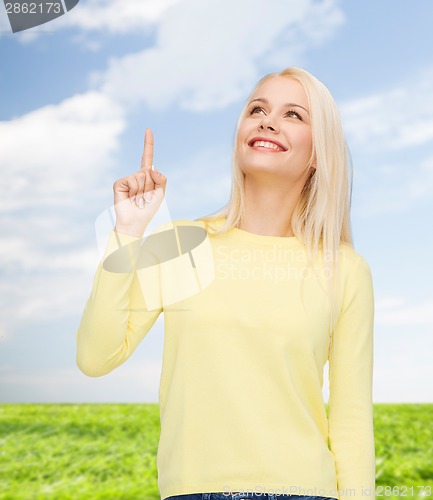 Image of smiling woman pointing her finger up