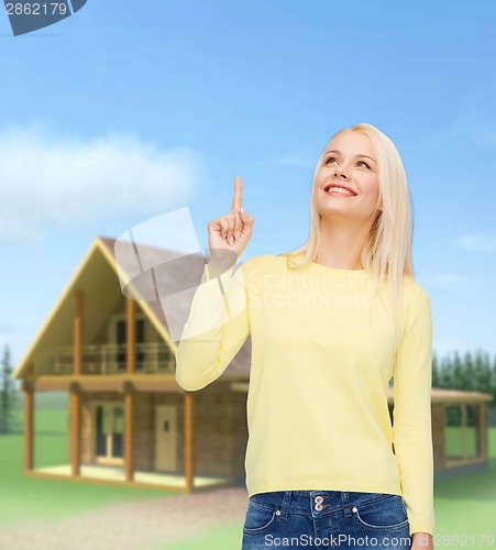 Image of smiling woman pointing her finger up