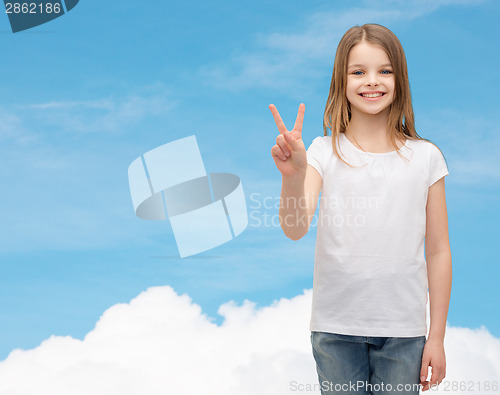 Image of little girl in white t-shirt showing peace gesture