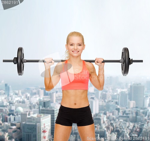 Image of smiling sporty woman exercising with barbell