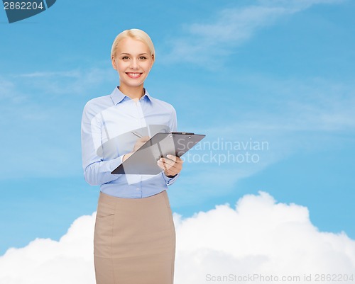 Image of smiling businesswoman with clipboard and pen