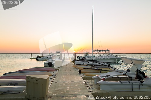 Image of boats moored to pier at sundown