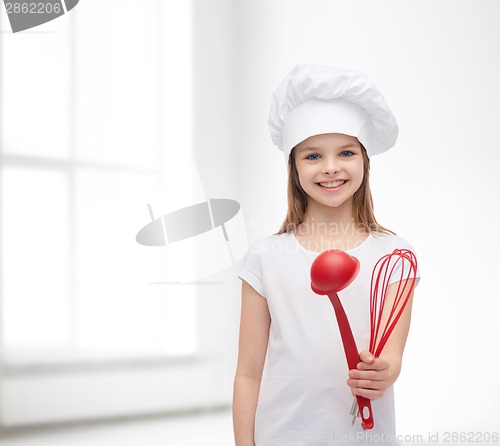 Image of smiling girl in cook hat with ladle and whisk