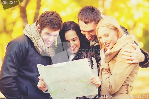 Image of couples with tourist map in autumn park