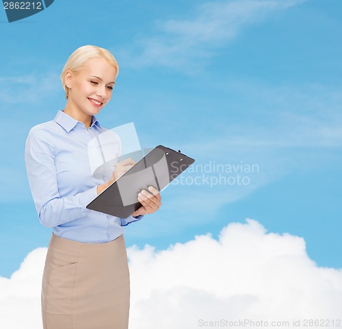 Image of smiling businesswoman with clipboard and pen