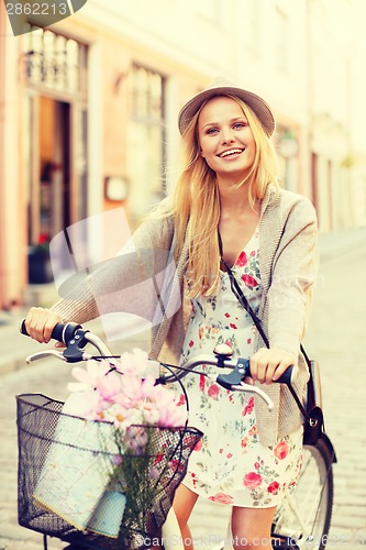 Image of attractive woman in hat with bicycle in the city