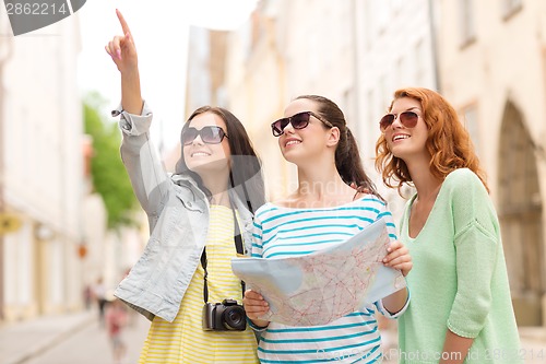 Image of smiling teenage girls with map and camera