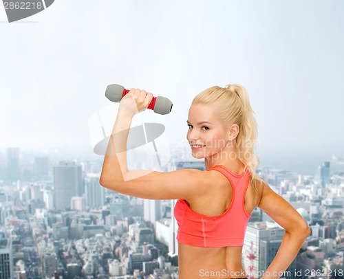 Image of young sporty woman with light dumbbell