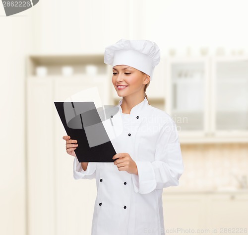 Image of smiling female chef with black blank paper