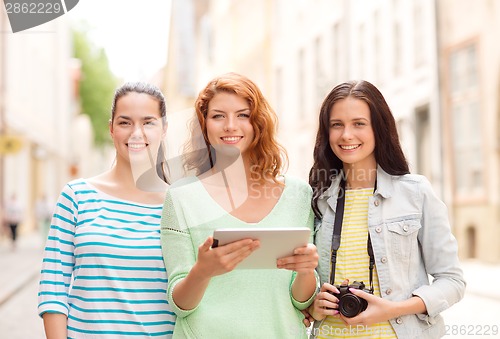 Image of smiling teenage girls with tablet pc and camera