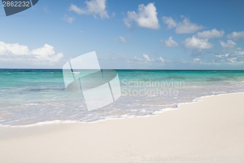 Image of blue sea or ocean, white sand and sky with clouds