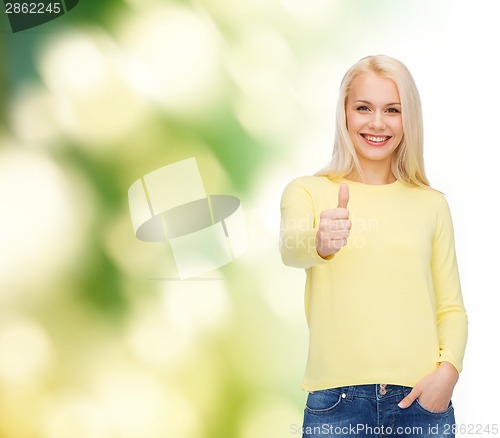 Image of smiling girl in casual clothes showing thumbs up