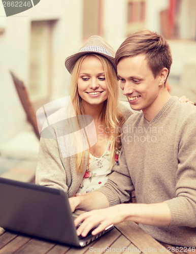 Image of couple with laptop in cafe