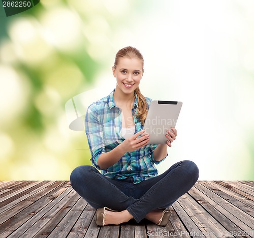 Image of young woman in casual clothes sitting on floor