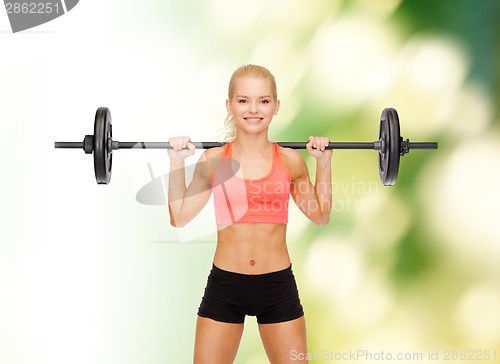 Image of smiling sporty woman exercising with barbell