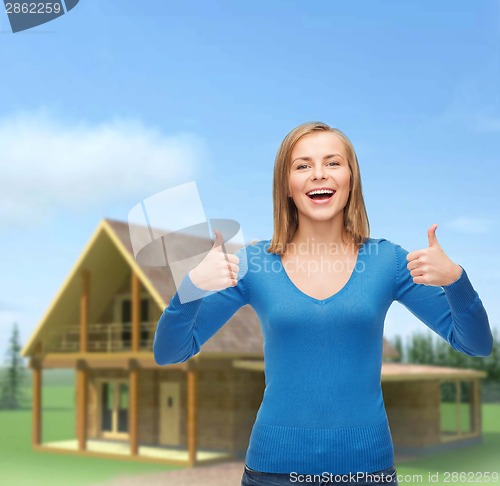 Image of smiling girl in casual clothes showing thumbs up