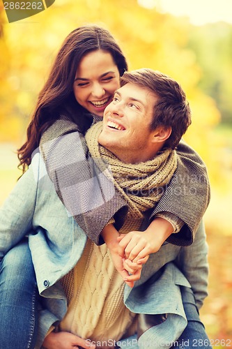 Image of romantic couple playing in the autumn park