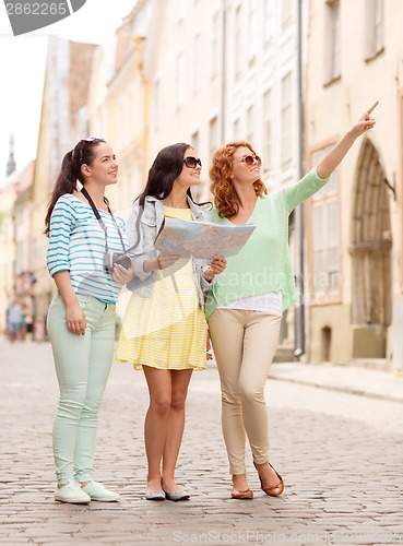 Image of smiling teenage girls with map and camera