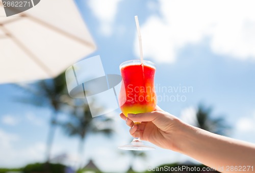 Image of close-up of hand holding glass with cocktail