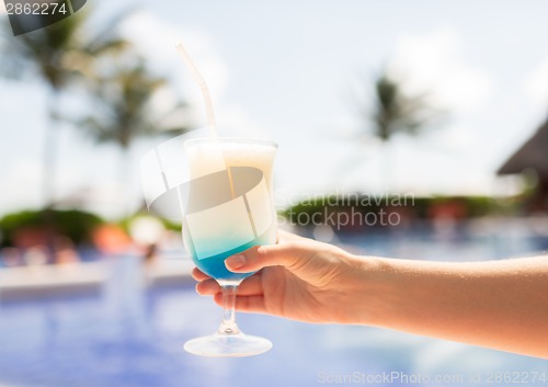 Image of close-up of hand holding glass with cocktail